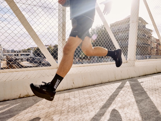 Long shot of a woman and a man wearing Brooks Running clothing on rocky track